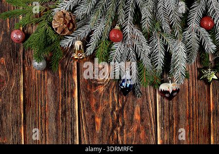 Christmas and New Year 2024 background with fir branches in snow flakes, toys and decorations on an old wooden table, banner for Stock Photo