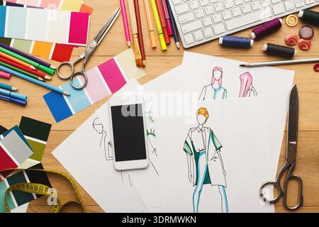 Fashion Design Workspace With Sketches, Tools, and Colorful Materials Organized on a Table Stock Photo