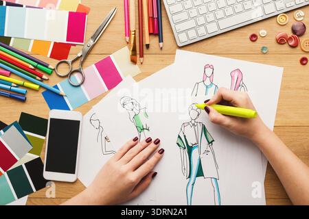 Hand Drawing Fashion Designs on Paper With Color Palettes and Tools at Workspace Stock Photo
