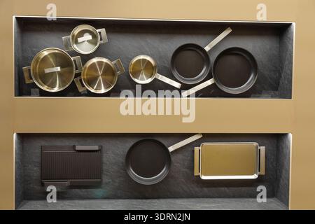 Modern kitchen cookware collection displayed on sleek shelving unit Stock Photo