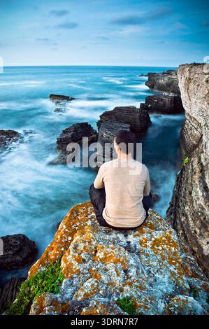 Man Sitting on Top of Rock Stock Photo