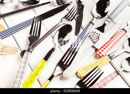 Collection of Various Silverware Arranged in a Random Pattern on a Light Surface Stock Photo