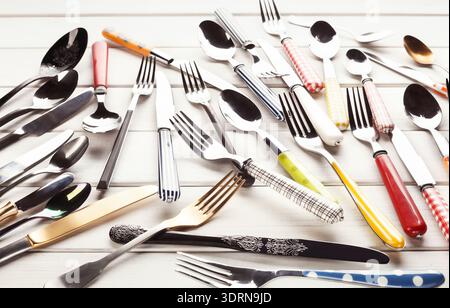 Collection of Various Forks and Spoons Arranged on a Light Wooden Surface for Display Stock Photo