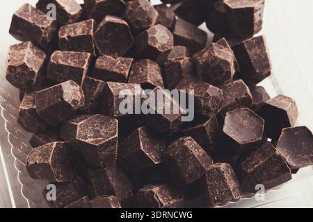 Tasty chocolate chips pile, closeup on white background Stock Photo