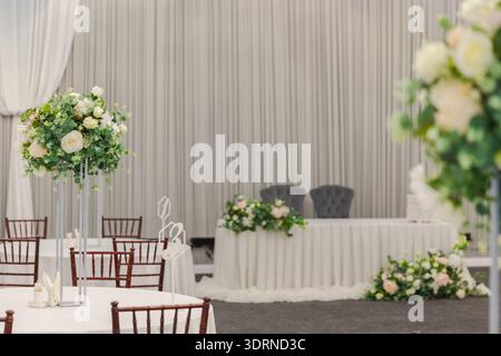 Decorated interior for festive event. Fancy table set for dinner with white flower composition in restaurant, luxury interior ba Stock Photo