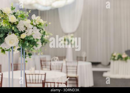 Decorated interior for festive event. Fancy table set for dinner with white flower composition in restaurant, luxury interior ba Stock Photo