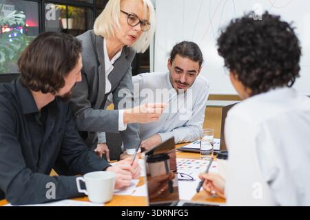 Teamwork brainstorm. Coworkers cooperating working together at office meeting. Colleagues discussing project ideas. Group of peo Stock Photo