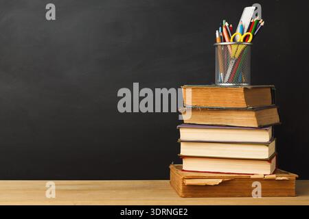 Stack of Books and Pencil Holder on a Desk in a Classroom Setting During the Day Stock Photo