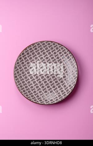 An empty round ceramic plate on a pink background as a kitchen utensil. An empty plate as a food background for your design Stock Photo