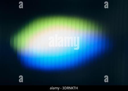 glowing light creating vibrant green, white and blue gradient pattern on blurred ribbed glass Stock Photo