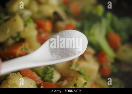 Cooking a vegetable dish with salt on a spoon Stock Photo