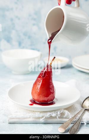 Red wine poached pears in spicy syrup Stock Photo