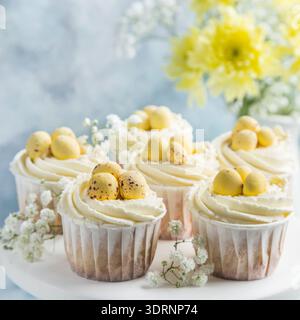 Easter cupcakes decorated with cream cheese frosting and candy eggs Stock Photo