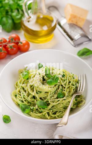Spaghetti pasta with basil pesto sauce and parmesan cheese on white bowl Stock Photo