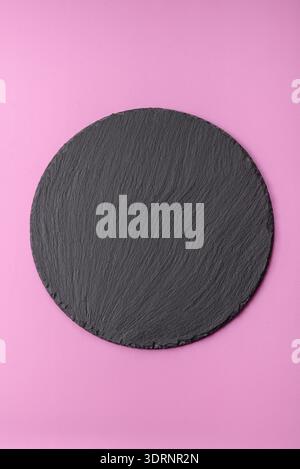 An empty round ceramic plate on a pink background as a kitchen utensil. An empty plate Stock Photo