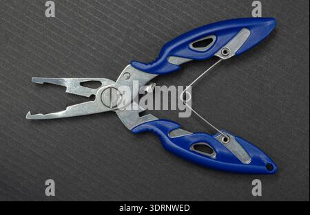 Fishing multitool close-up on a black background Stock Photo