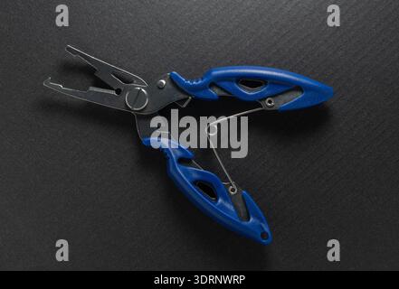 Fishing multitool close-up on a black background Stock Photo