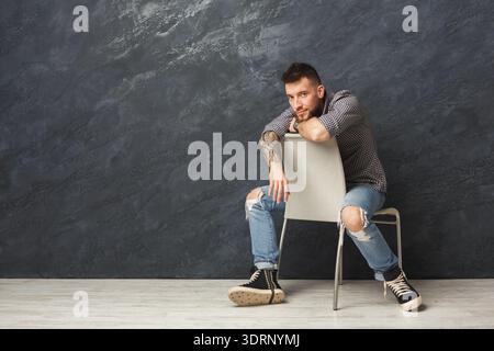 Collection of a Man Sitting on a Chair in a Modern Set With a Dark Background Stock Photo