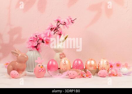 Beautiful Easter banner with decorated festive eggs, sakura and cherry blossom branches, rabbits and feathers. Happy Easter conc Stock Photo