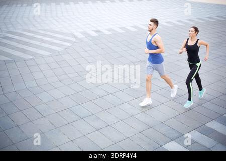 Running Together on a City Pavement in the Early Morning Light Stock Photo