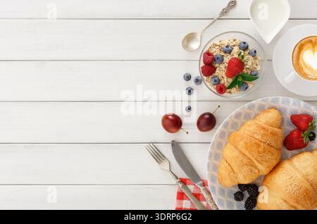 Enjoying Breakfast With Croissants, Fruits, and Coffee at a Cozy Kitchen Table Stock Photo