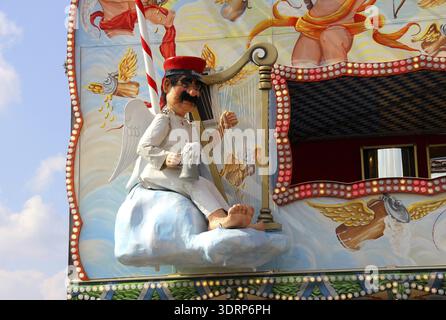 Cult figure Aloisius playing a harp in heaven, with red service cap, beer mug in hand, as a doll on the outer wall of a pleasure establishment at Okto Stock Photo
