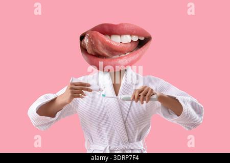 Young woman with mouth instead of head applying tooth paste onto brush on pink background Stock Photo