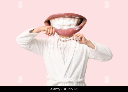Young man with mouth instead of head applying tooth paste onto brush on light pink background Stock Photo