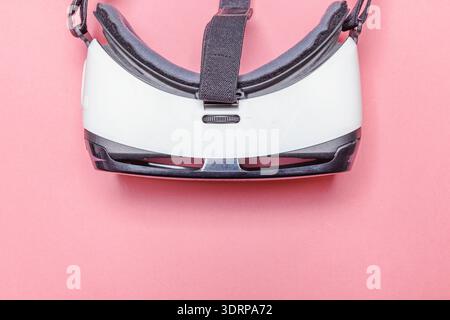 Minimal simple flat lay with virtual reality VR glasses helmet headset on pink pastel trendy modern background Stock Photo