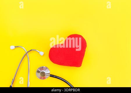 Medicine equipment stethoscope or phonendoscope and red heart isolated on trendy yellow background Stock Photo