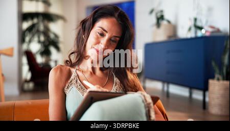 Writing, journal and woman with notebook in home for reminder, checklist or mental health. Planning, notes and mature person with diary for reflection Stock Photo