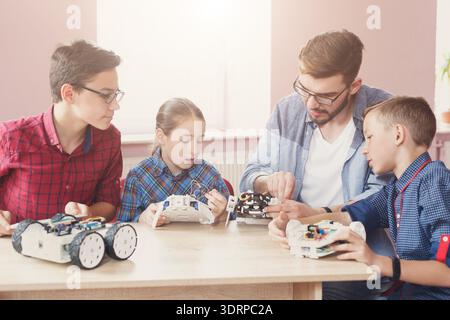 Students and Teacher Work Together on Robotics Projects in a Classroom Setting Stock Photo