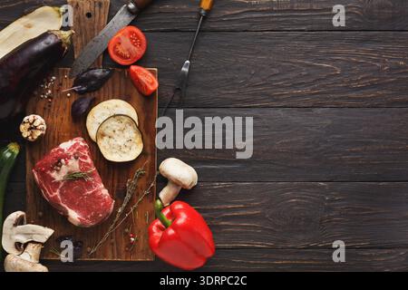 Fresh Meat and Vegetables Arranged on a Wooden Cutting Board Before Cooking Stock Photo