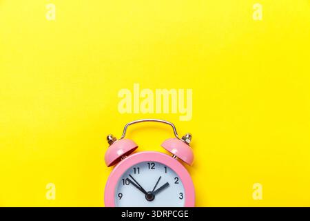 Vintage alarm clock Isolated on yellow background Stock Photo
