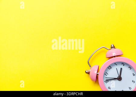 Vintage alarm clock Isolated on yellow background Stock Photo
