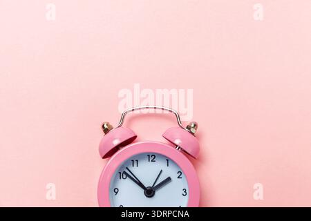 Vintage alarm clock Isolated on pink pastel background Stock Photo