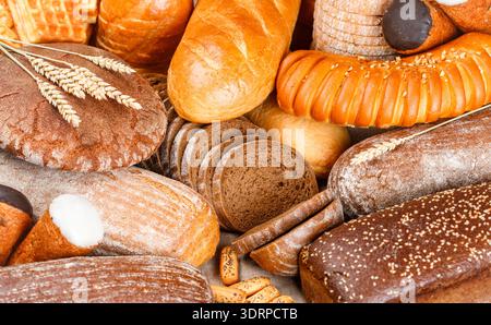 Freshly baked rye and wheat bread on the table. Whole and sliced loaves Stock Photo