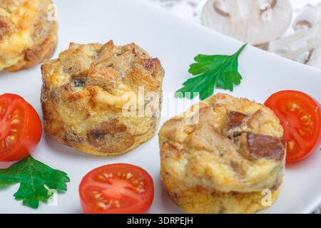 Omelette with mushrooms, parsley, cherry tomatoes and bread croutons.  Scrambled eggs. Tortilla. Frittata. Traditional tasty Bre Stock Photo