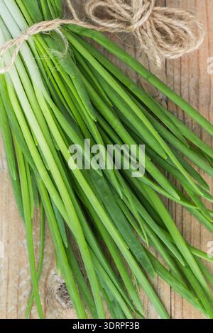 Fresh organic green onions on an old wooden table. Selective focus Stock Photo