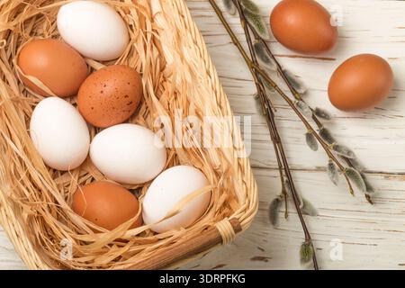 White and brown eggs in the basket on the table. Easter Stock Photo