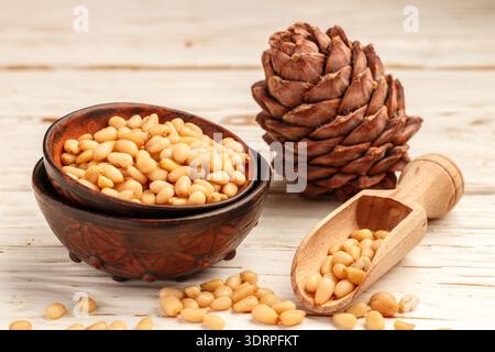 Cedar (Pine) nuts and cones on white wooden table. Selective focus Stock Photo