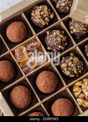 Set of chocolate truffles with nuts and cocoa. Tasty round candy. A delicious gift in a Kraft paper box. Holiday concept. Select Stock Photo