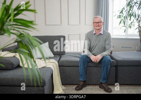 Portrait of confident stylish European middle aged senior man at home. Older mature 70s man smiling. Happy attractive senior gra Stock Photo
