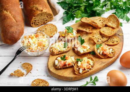 Rye bread chips. A delicious snack of whole-grain slices bread with seeds and a salad of salted or smoked fish (salmon or trout) Stock Photo