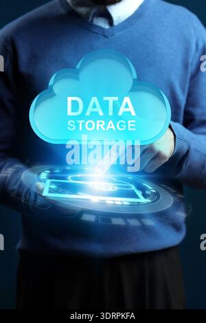 Person interacts with digital cloud symbol for data storage at an office setting Stock Photo