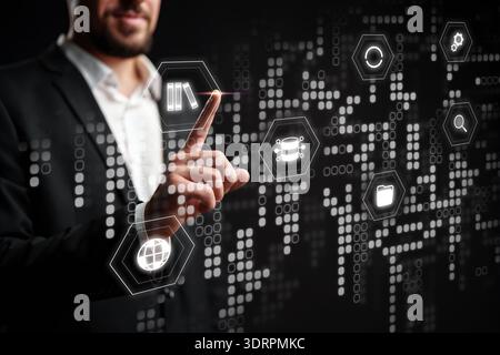 Businessman interacts with digital interface showing data and technology symbols Stock Photo