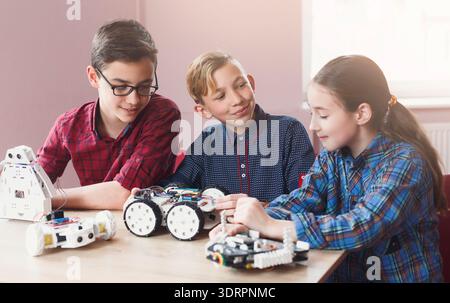 Kids Learn Robotics Skills Together While Working on Projects in a Classroom Setting Stock Photo