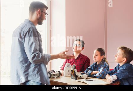 Students Learn About Robotics in a Workshop Setting With a Mentor Present Stock Photo