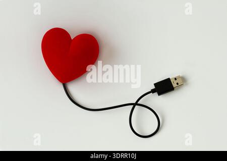 Heart connected with USB Cable on white background - Concept of love Stock Photo
