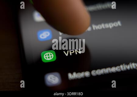 smartphone screen showing the VPN settings menu with a finger hovering above the icon, representing virtual private network security, anonymous browsi Stock Photo